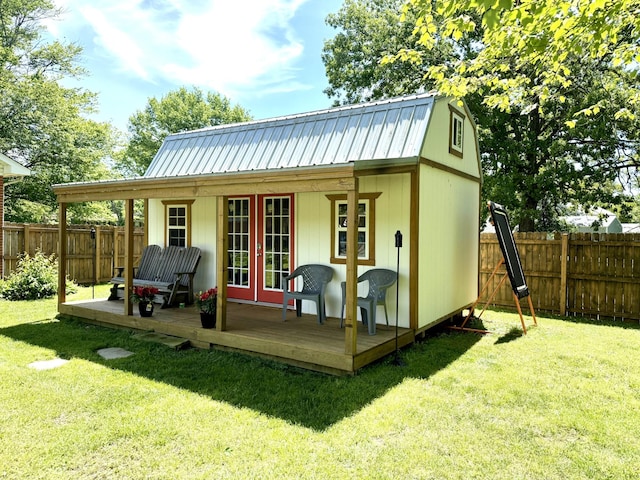 back of house with metal roof and an outbuilding
