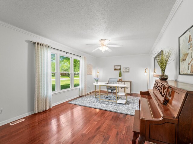 office space with crown molding, ceiling fan, a textured ceiling, wood finished floors, and baseboards