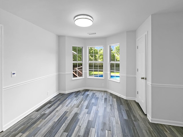 unfurnished room featuring dark wood finished floors and baseboards
