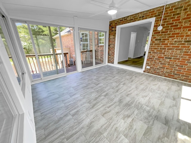 unfurnished sunroom with ceiling fan