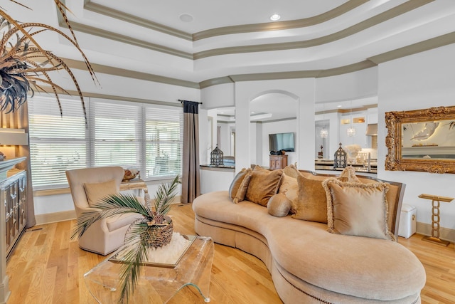 1041 Albatross Way, Gallatin, TN 37066 - living room featuring a tray ceiling, crown molding, arched walkways, light wood-type flooring, and baseboards