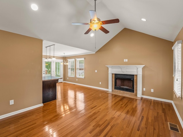 30 Sullivan Ln, Tullahoma, TN 37388 - unfurnished living room with ceiling fan, a tiled fireplace, light wood finished floors, baseboards, and lofted ceiling