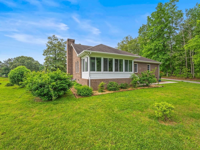 30 Sullivan Ln, Tullahoma, TN 37388 - view of property exterior featuring a chimney, brick siding, and a lawn