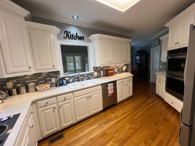 3411 Meadowcrest Dr, Murfreesboro, TN 37129 - kitchen with stainless steel appliances, crown molding, a sink, white cabinetry, and backsplash
