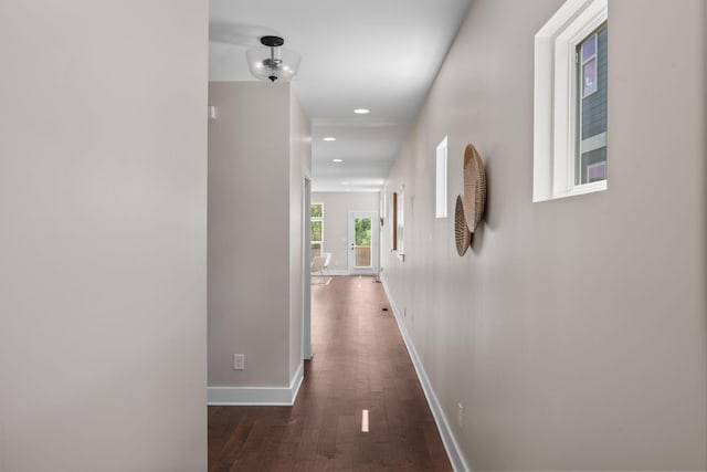 hall with dark wood-type flooring, baseboards, and recessed lighting