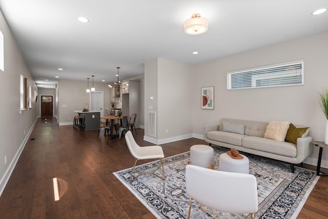 living area with dark wood-type flooring, baseboards, and recessed lighting