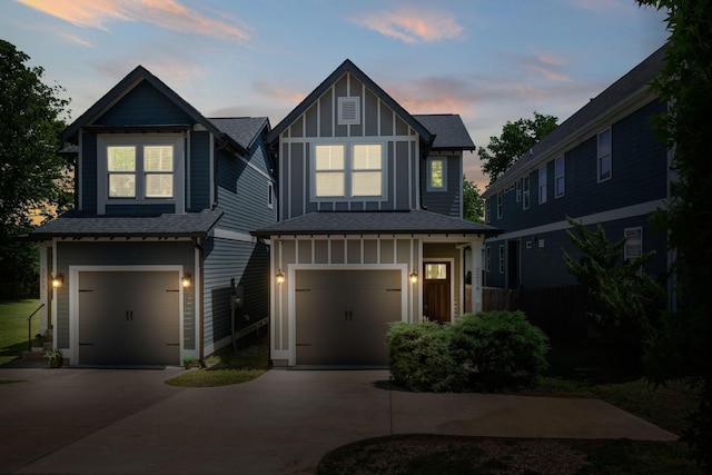 view of front of home featuring an attached garage, driveway, board and batten siding, and roof with shingles