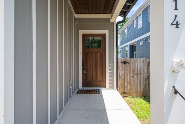 property entrance with board and batten siding and fence