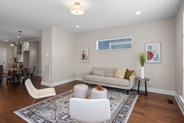 living area with dark wood-style flooring, baseboards, and recessed lighting