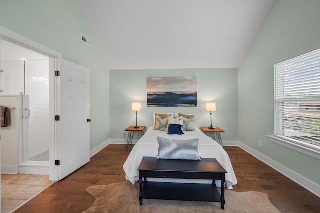 bedroom with lofted ceiling, wood finished floors, ensuite bath, and baseboards