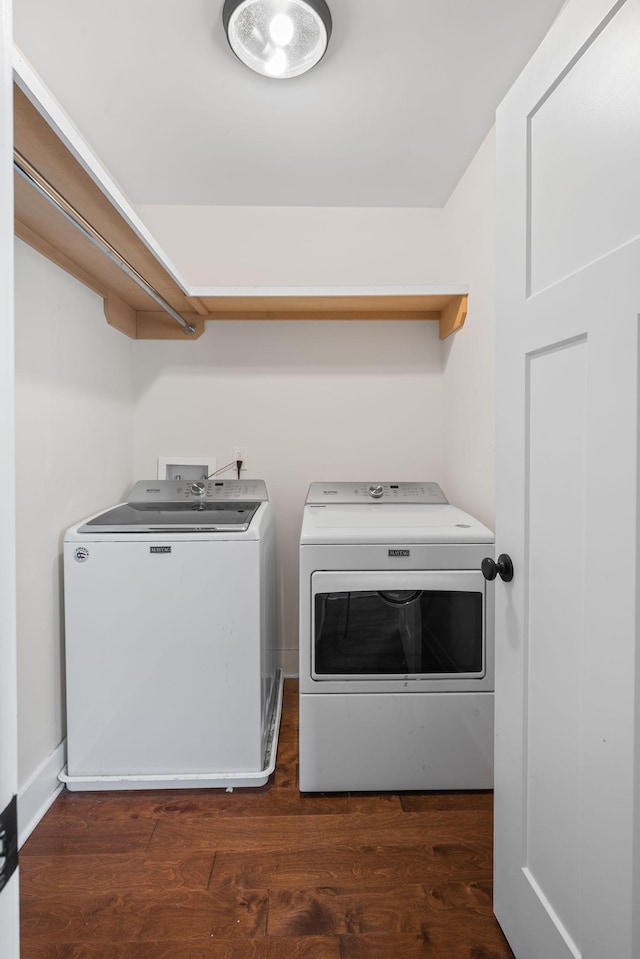 clothes washing area featuring washing machine and clothes dryer and wood finished floors