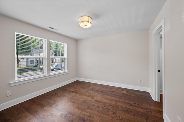 unfurnished room featuring dark wood-style floors and baseboards