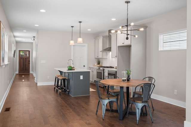 dining area with dark wood-type flooring, plenty of natural light, recessed lighting, and baseboards