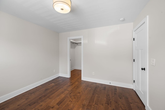 unfurnished bedroom with dark wood-type flooring, baseboards, and a closet
