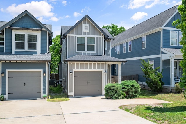 view of front facade with board and batten siding, driveway, a shingled roof, a garage, and fence