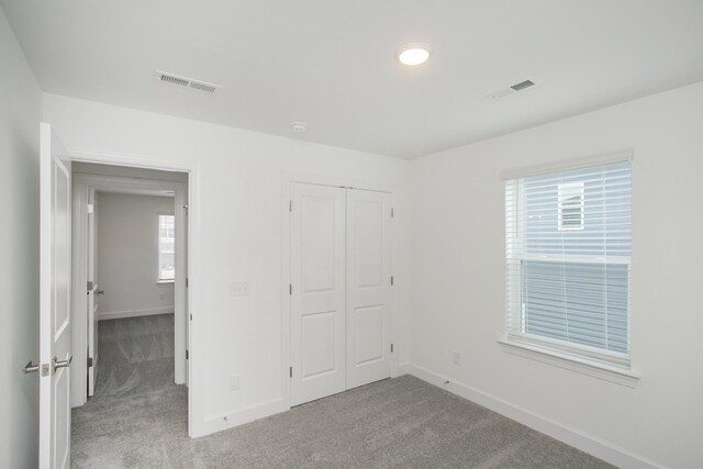 unfurnished bedroom with carpet floors, baseboards, and a closet