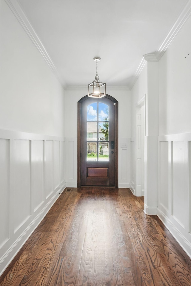 entryway featuring a decorative wall, ornamental molding, dark wood-style flooring, and a wainscoted wall