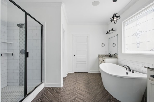 full bathroom featuring a shower stall, ornamental molding, baseboards, a soaking tub, and vanity