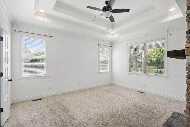 unfurnished room featuring crown molding, a raised ceiling, plenty of natural light, baseboards, and recessed lighting