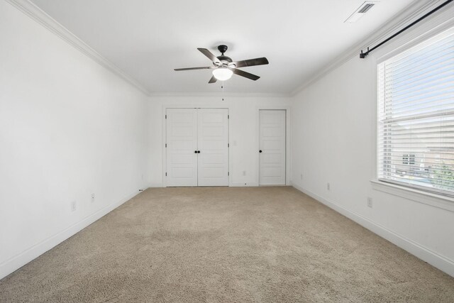 unfurnished bedroom with ornamental molding, light carpet, baseboards, and ceiling fan