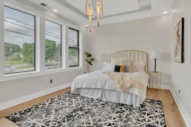 bedroom featuring wood finished floors, baseboards, and recessed lighting