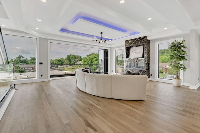 living area featuring a chandelier, light wood-style flooring, recessed lighting, baseboard heating, and a tray ceiling