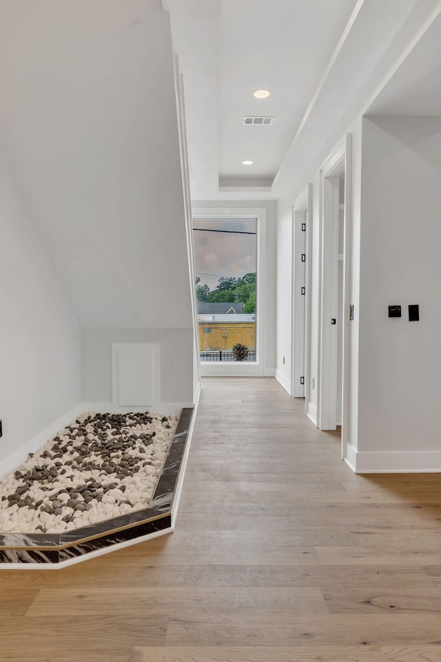 hallway featuring wood finished floors, baseboards, and recessed lighting