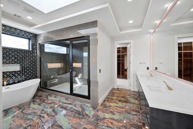 full bath featuring a shower stall, a freestanding tub, marble look tiles, recessed lighting, and double vanity
