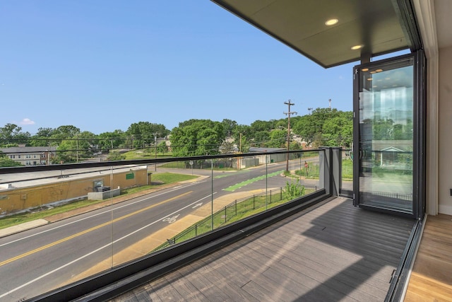 balcony featuring view of wooded area