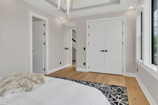 bedroom with light wood-style floors, baseboards, a closet, and recessed lighting