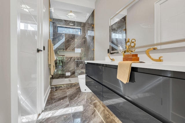 bathroom featuring marble tiled floors, a marble finish shower, double vanity, and toilet