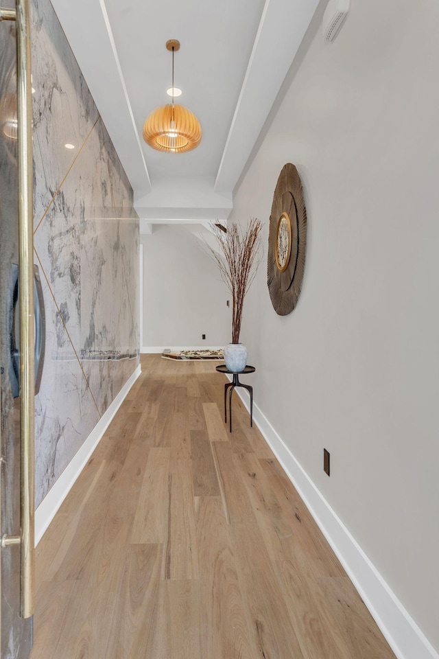 hallway with light wood-style flooring and baseboards