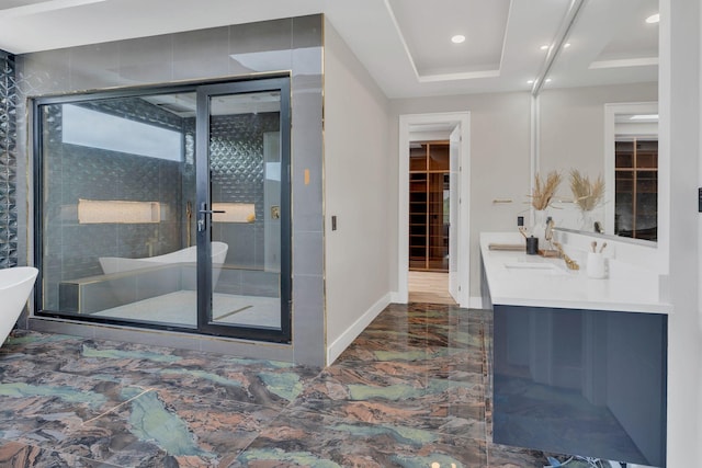full bath with a stall shower, marble finish floors, baseboards, vanity, and a freestanding bath