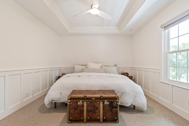 3060 Liberty Hills Dr, Franklin, TN 37067 - carpeted bedroom featuring a raised ceiling, multiple windows, a decorative wall, wainscoting, and a ceiling fan