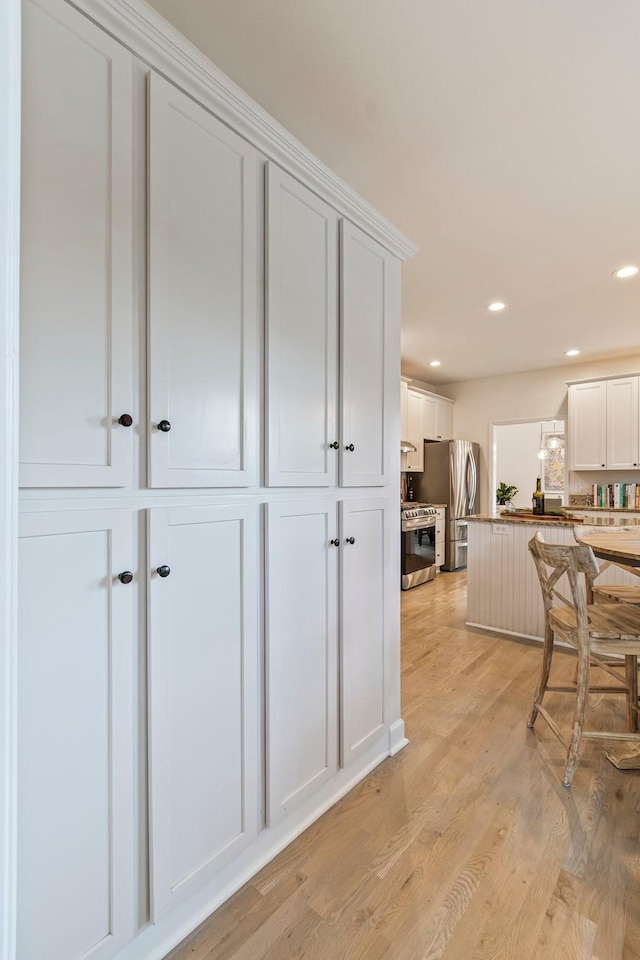 3060 Liberty Hills Dr, Franklin, TN 37067 - kitchen with stainless steel appliances, white cabinets, light wood finished floors, recessed lighting, and a peninsula