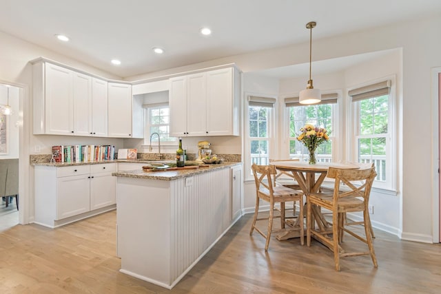 3060 Liberty Hills Dr, Franklin, TN 37067 - kitchen featuring light wood-type flooring, white cabinets, light stone counters, a peninsula, and recessed lighting