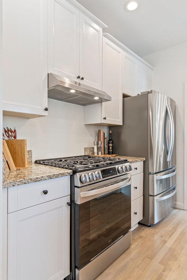 3060 Liberty Hills Dr, Franklin, TN 37067 - kitchen featuring appliances with stainless steel finishes, under cabinet range hood, light wood-type flooring, white cabinetry, and light stone countertops