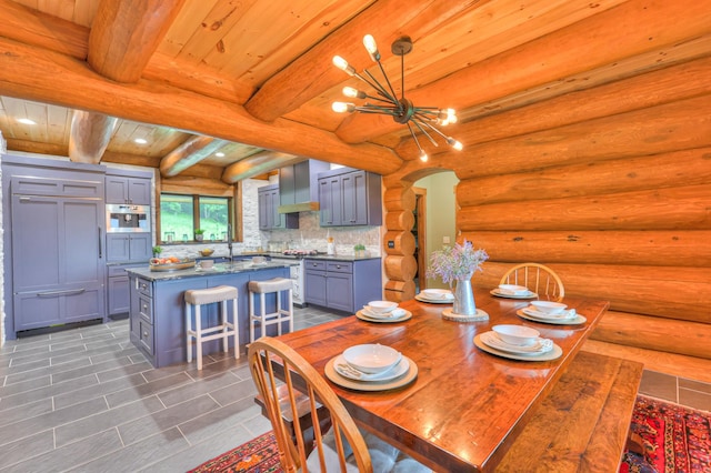 1271 Bivins Rd, Lewisburg, TN 37091 - dining room with a chandelier, dark tile patterned flooring, rustic walls, wood ceiling, and beamed ceiling