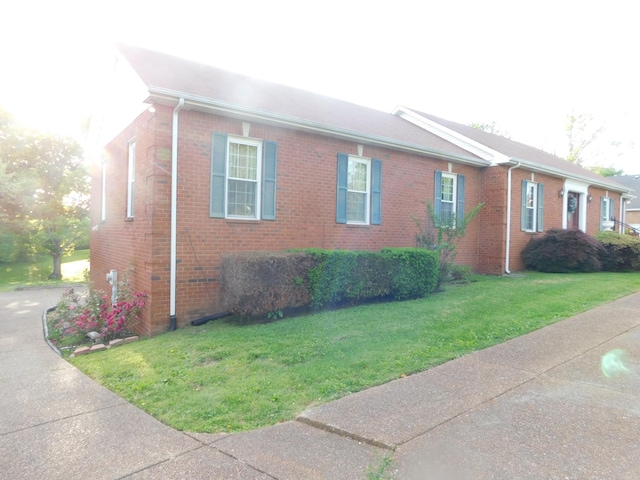 1129 Adam Dr, Cottontown, TN 37048 - view of property exterior featuring brick siding and a lawn