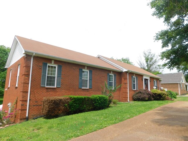 1129 Adam Dr, Cottontown, TN 37048 - view of side of home featuring brick siding and a lawn