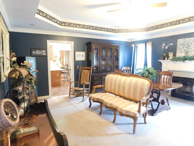 1129 Adam Dr, Cottontown, TN 37048 - living room with crown molding, a tray ceiling, a fireplace, carpet, and a ceiling fan