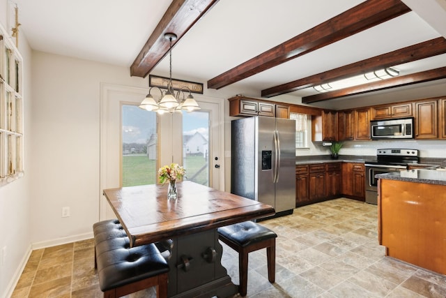 kitchen with stainless steel appliances, dark countertops, stone finish flooring, a chandelier, and baseboards