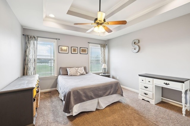 carpeted bedroom featuring a raised ceiling, ornamental molding, baseboards, and ceiling fan