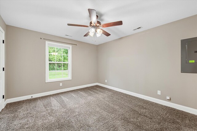 empty room featuring electric panel, baseboards, carpet flooring, and a ceiling fan