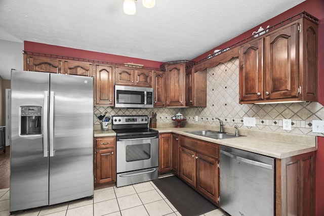 103 Nashay Ct, Portland, TN 37148 - kitchen featuring stainless steel appliances, a sink, light tile patterned floors, light countertops, and tasteful backsplash