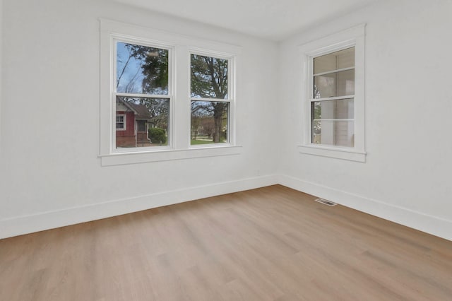 spare room with wood finished floors and baseboards