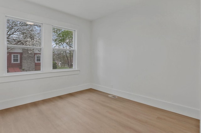 empty room with baseboards and light wood-type flooring