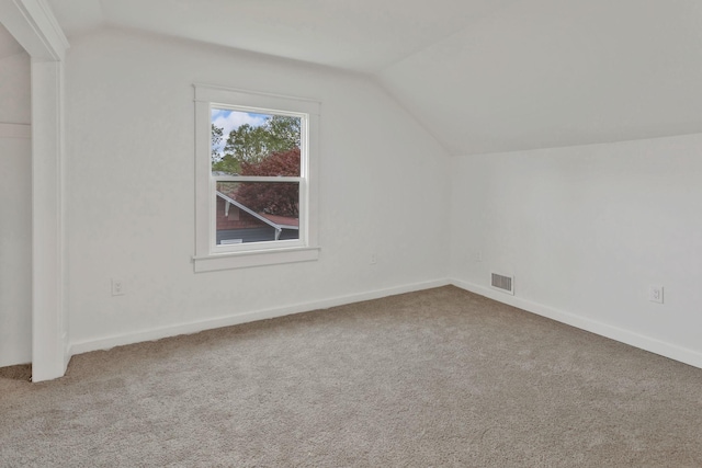 additional living space with vaulted ceiling, carpet flooring, and baseboards