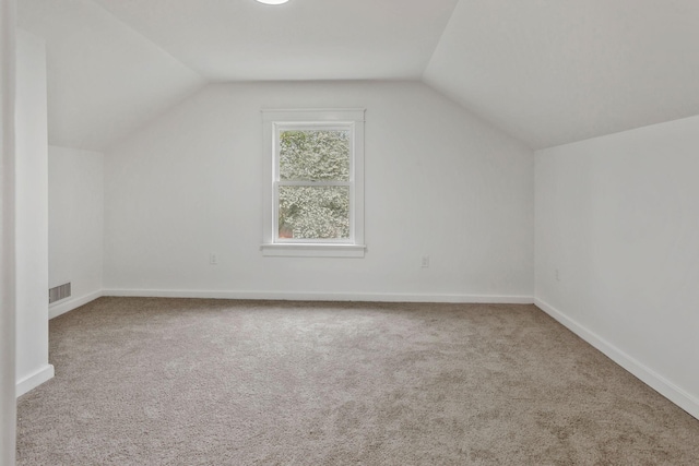 additional living space with vaulted ceiling, carpet, and baseboards