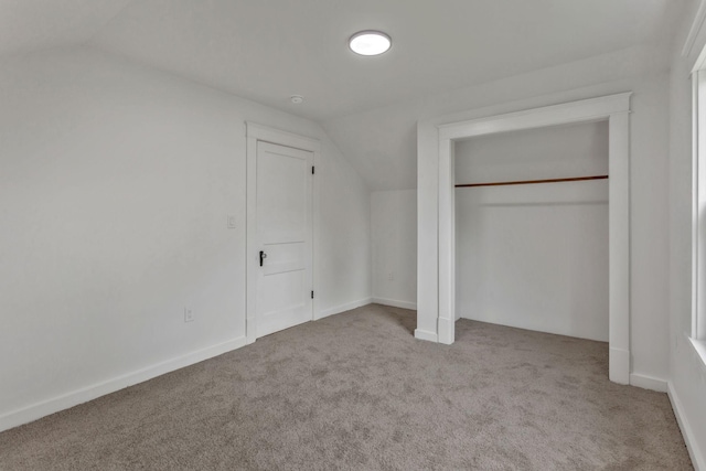 unfurnished bedroom with vaulted ceiling, carpet, and a closet